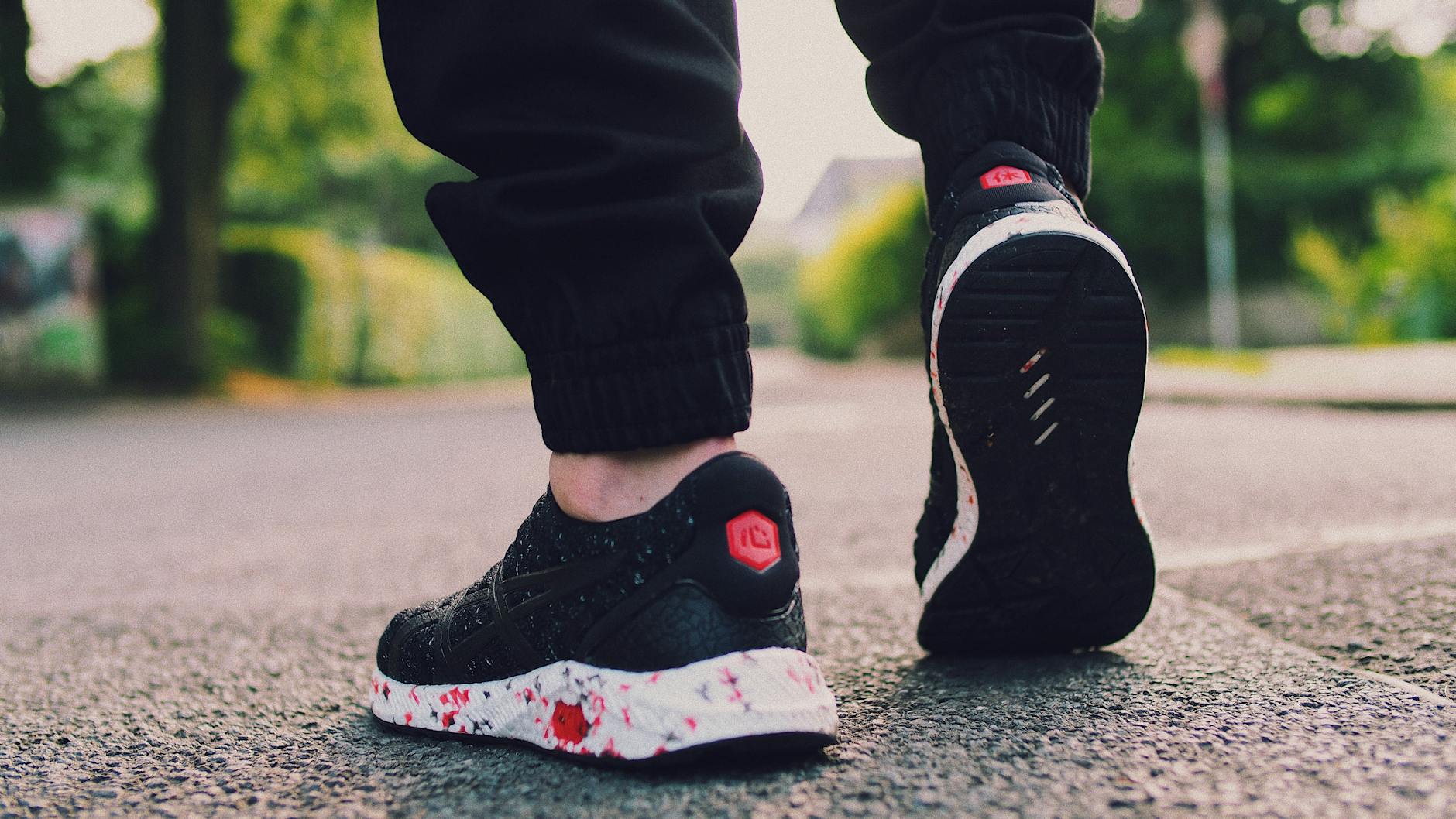 person in black sneakers walking on street