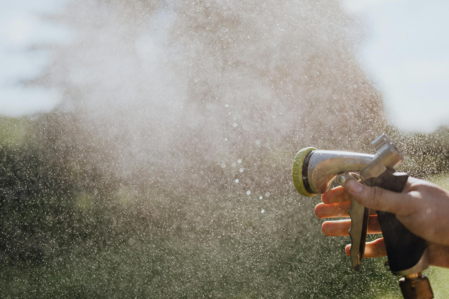 person s hand using a spray hose