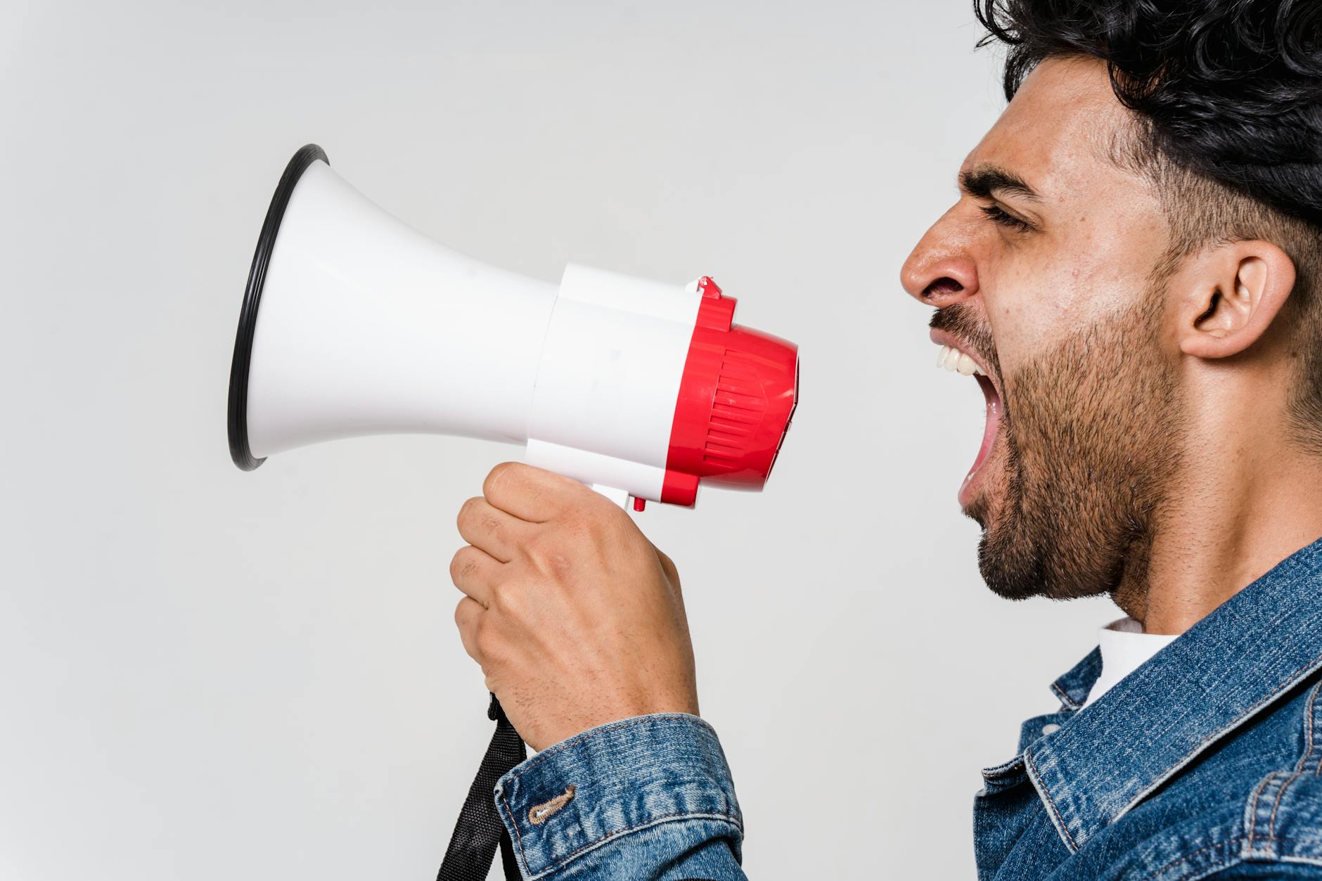 man in blue denim jacket holding a megaphone