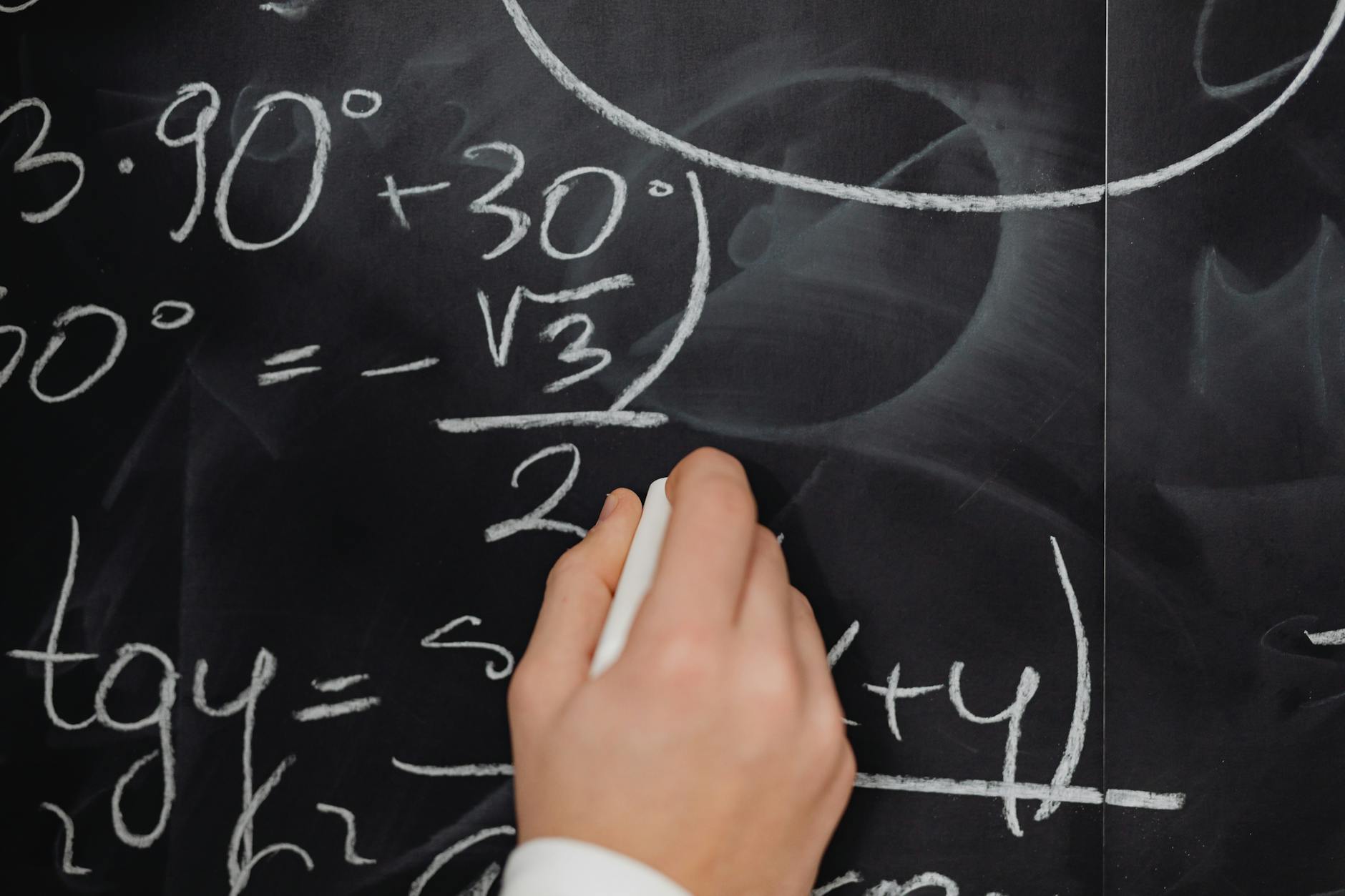 hand writing mathematical formulas on a blackboard